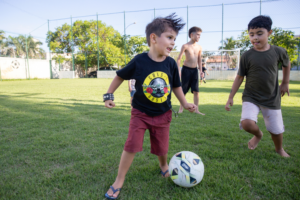 Crianças jogando futebol durante a comemoração.