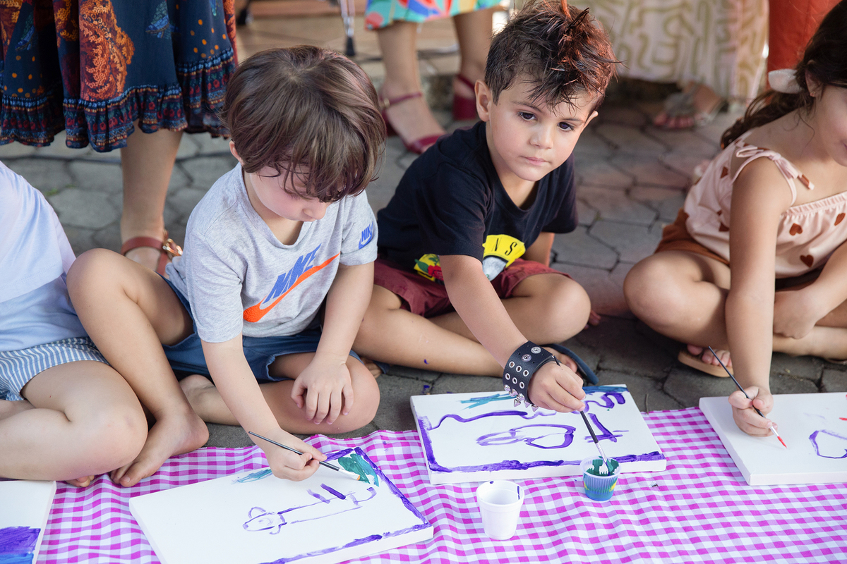 Crianças desenhando durante oficina recreativa na festa.