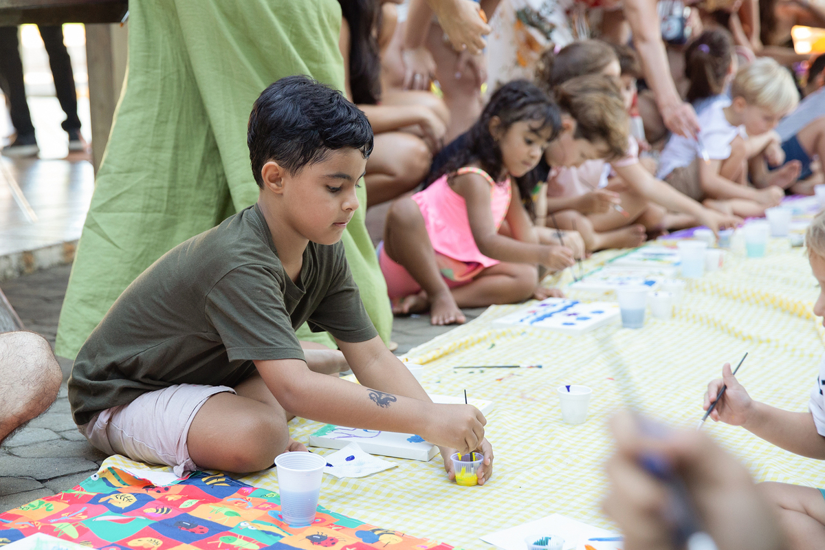 Crianças concentradas nas atividades de pintura.