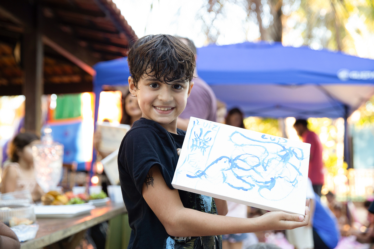 Amigo de Léo mostrando seu desenho com orgulho