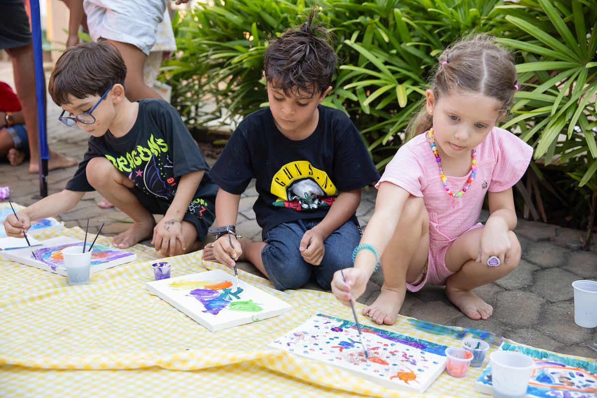 Crianças desenhando e se divertindo juntas.