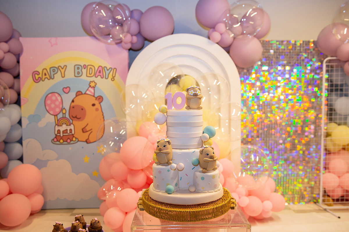 Cenário da festa infantil com decoração em tons lilás e tema Capivara.