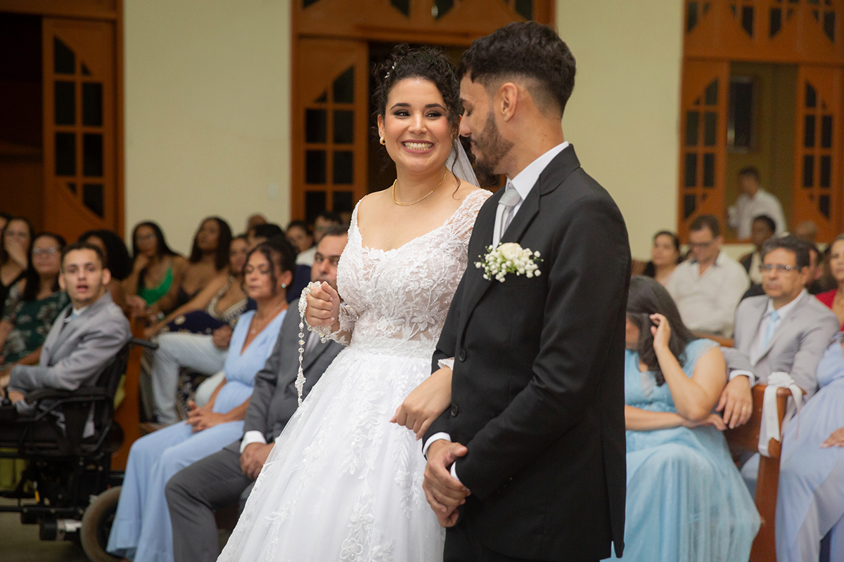 Retrato dos noivos sorrindo durante a celebração religiosa.