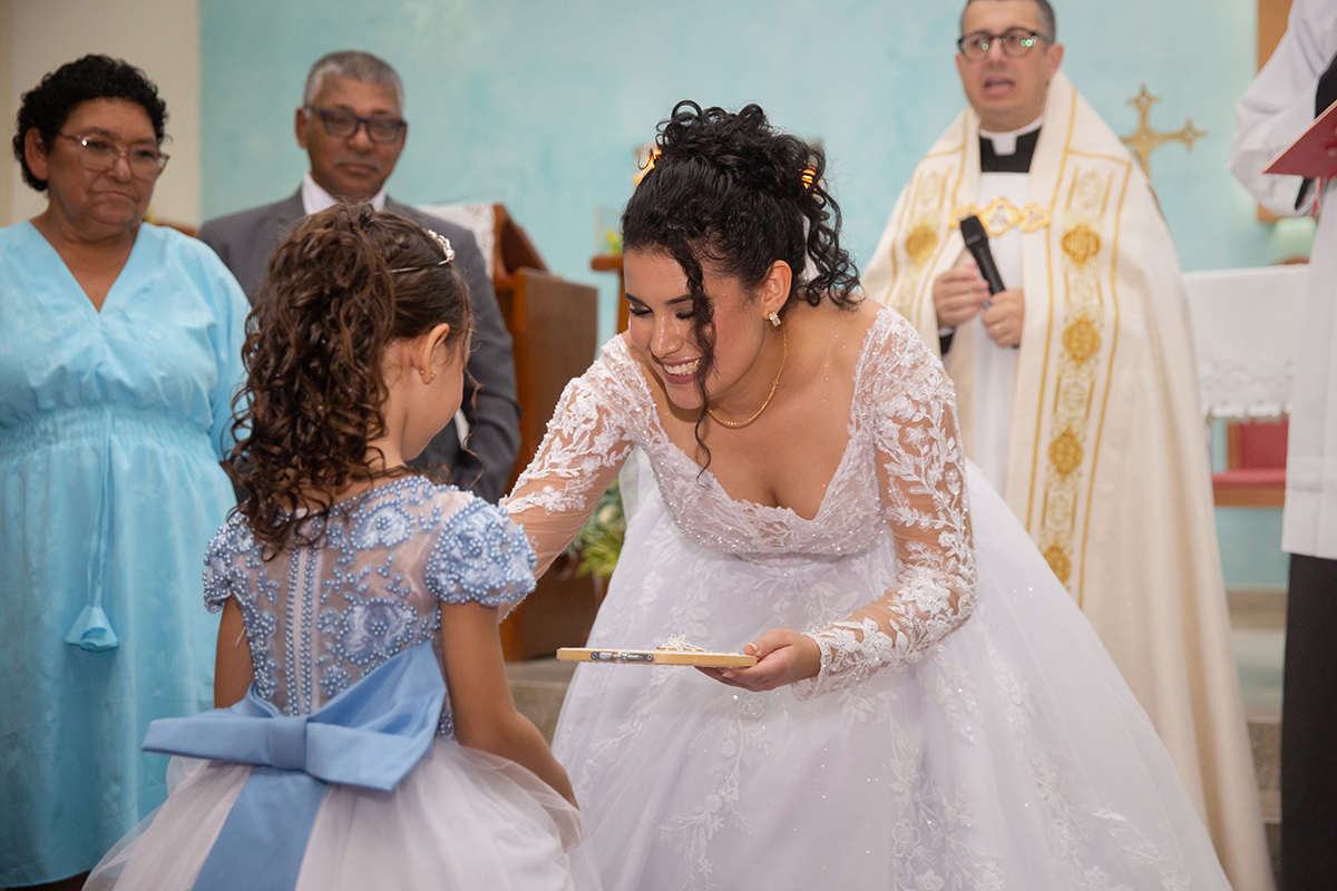 Momento emocionante entre noiva e daminha durante o casamento religioso.