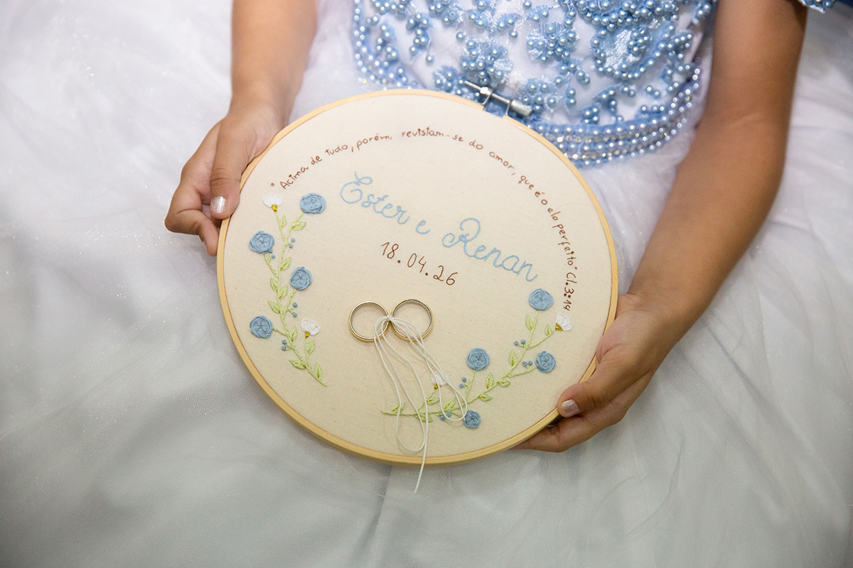 Detalhe das alianças sobre o porta-alianças personalizado do casamento de Ester e Renan.