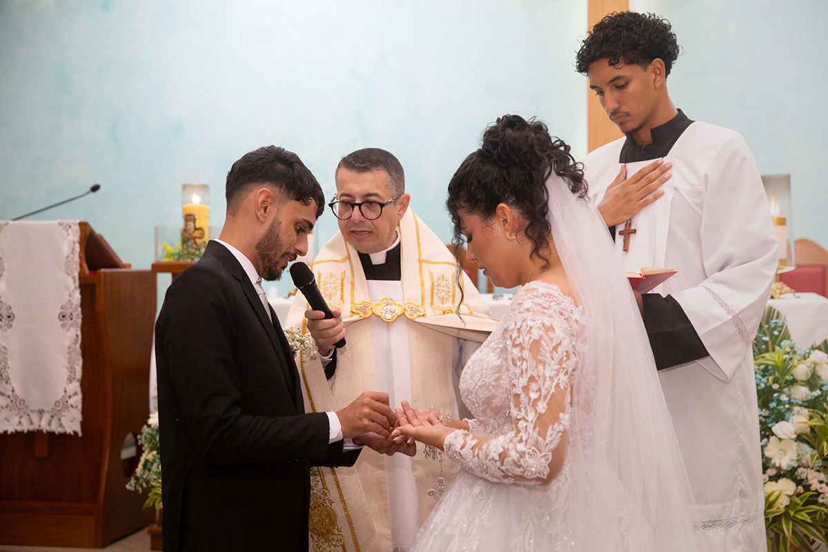 Noivos colocando as alianças em um dos momentos mais marcantes do casamento.