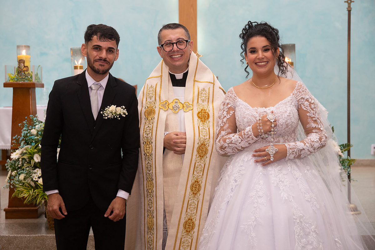 Retrato oficial dos noivos com o celebrante após a cerimônia.