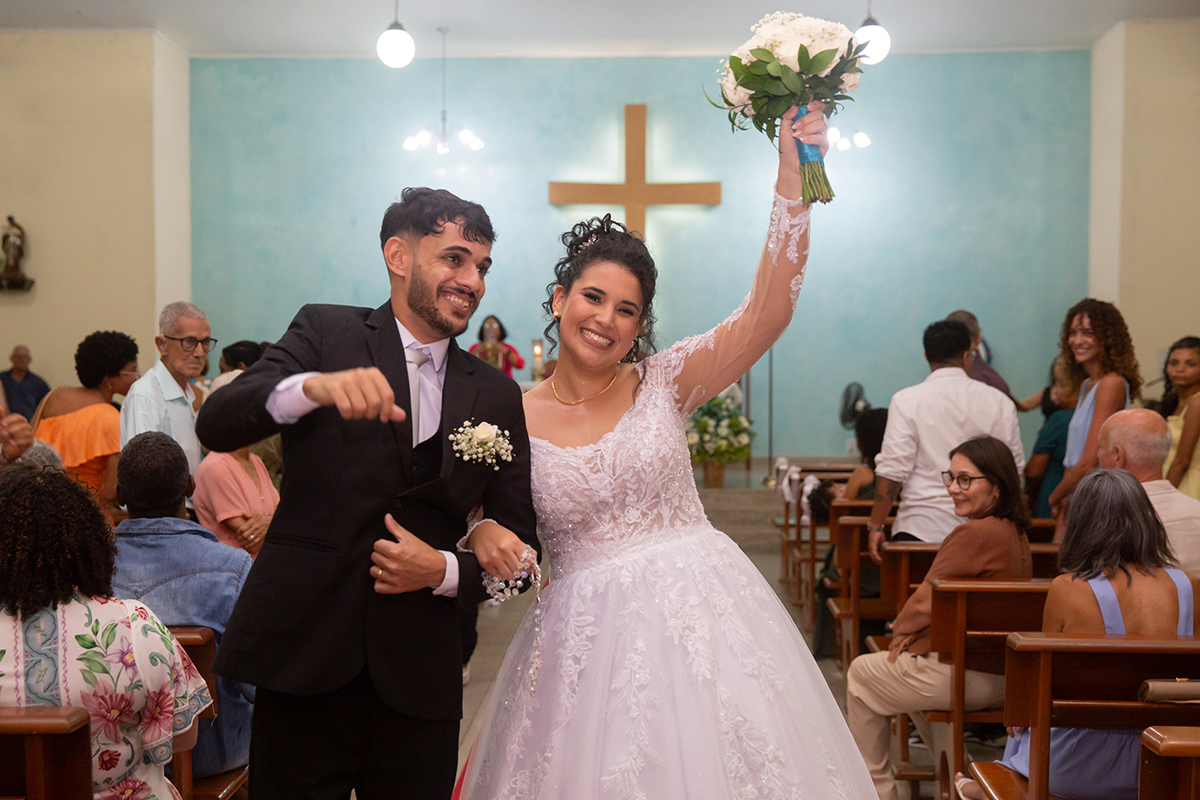 Noivos Ester e Renan comemorando a saída da cerimônia religiosa do casamento com muita alegria.