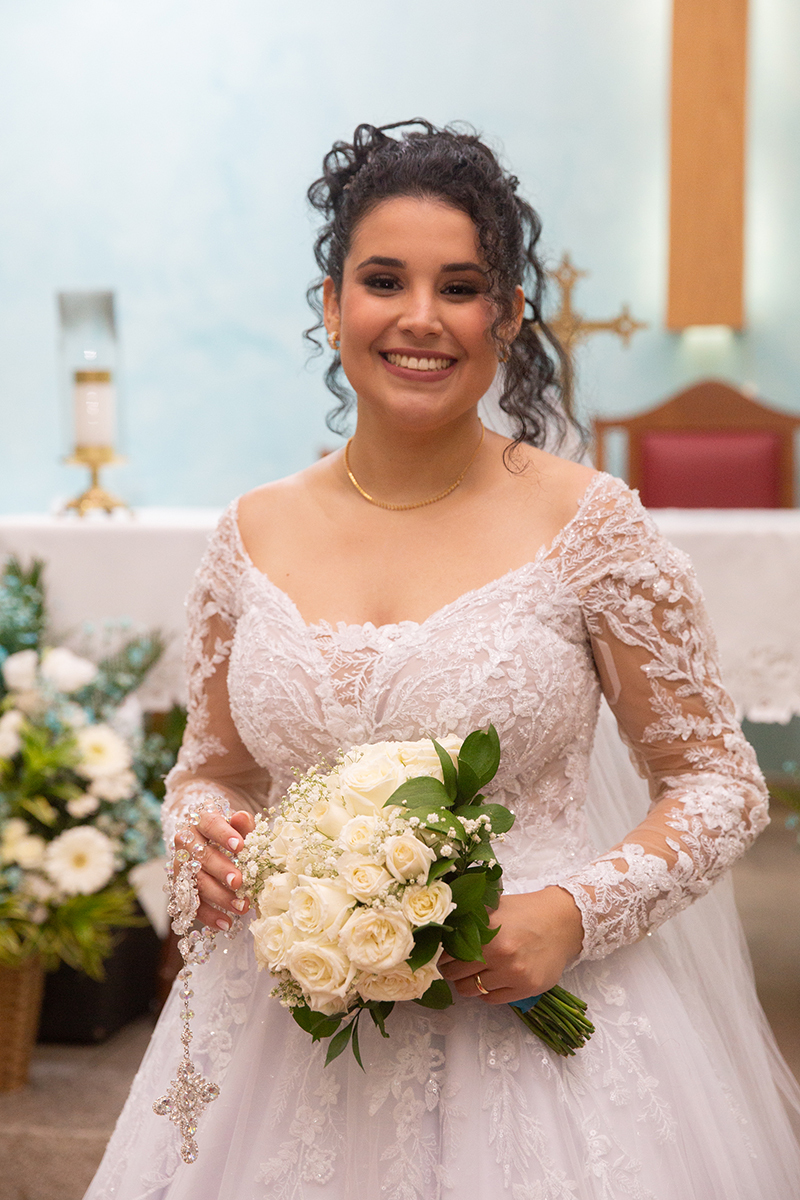 Close da noiva Ester sorrindo durante a cerimônia religiosa.