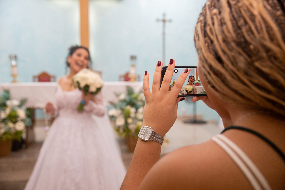 Convidada registrando a noiva na igreja.