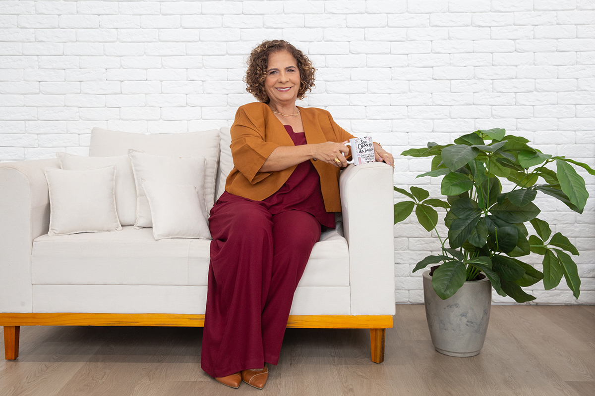 Corretora de imóveis Vera Lucia em ambiente clean durante sessão de fotos corporativas.
