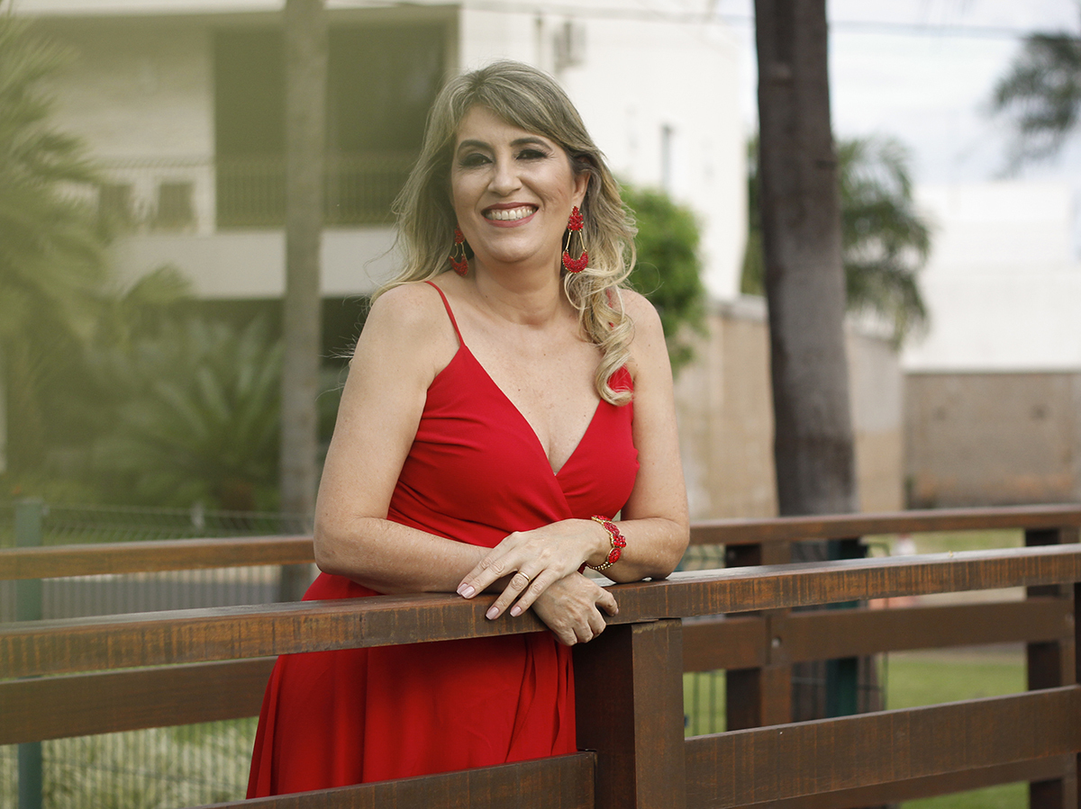 Mãe apoiada no corrimão da ponte olha para câmera