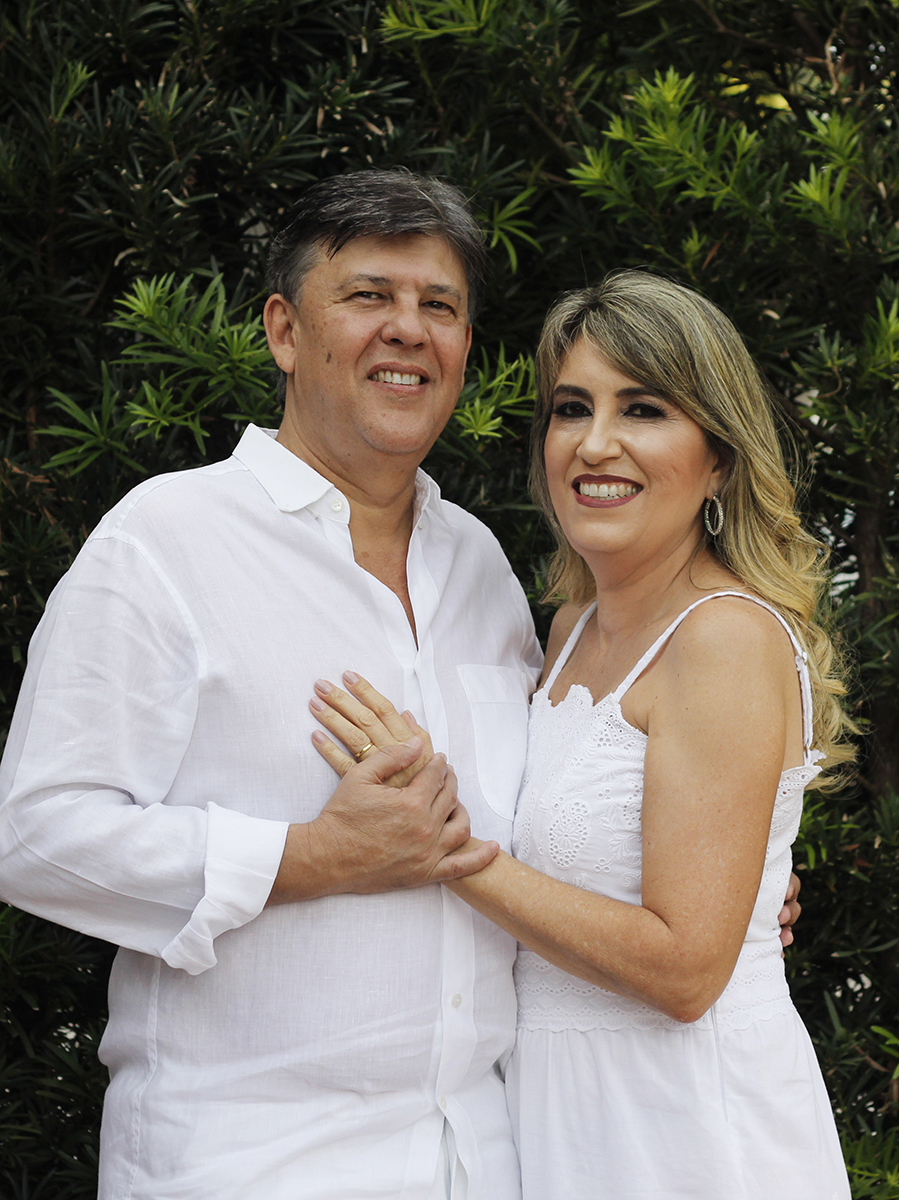 Casal posa em frente a casa