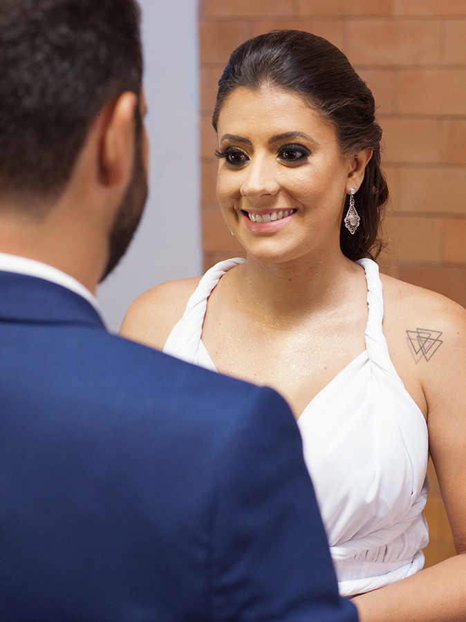 detalhe da noiva olhando e sorrindo para noivo no momento dos votos