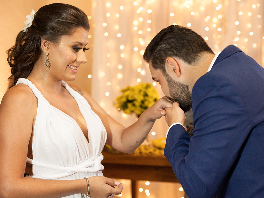 Noivo beija aliança que acabou de colocar na noiva