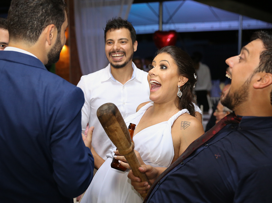 Corte da gravata. Noivo, amigos e noiva comemoram gritando