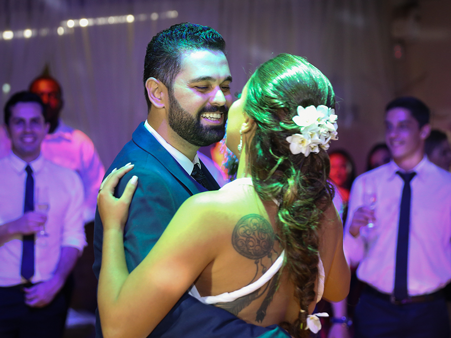 Noivos fazem a primeira dança. Detalhe do noivo olhando e sorrindo para noiva