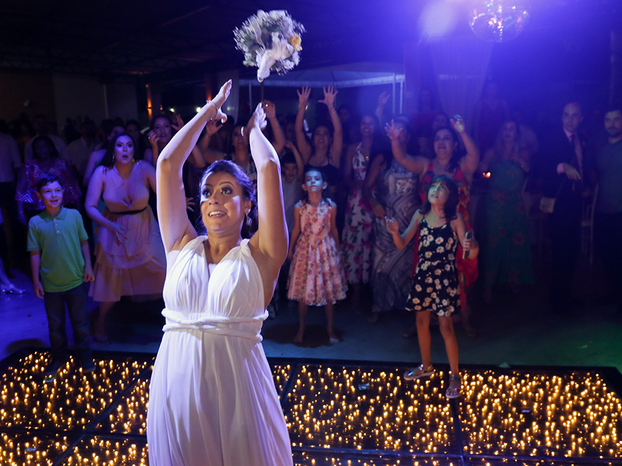 Tão esperada hora de jogar o buquê. Visão aberta da noiva jogando o buquê e buquê voando em direção as convidadas