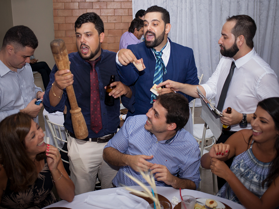 Corte da gravata. Noivo e amigos gritam e se divertem com convidados