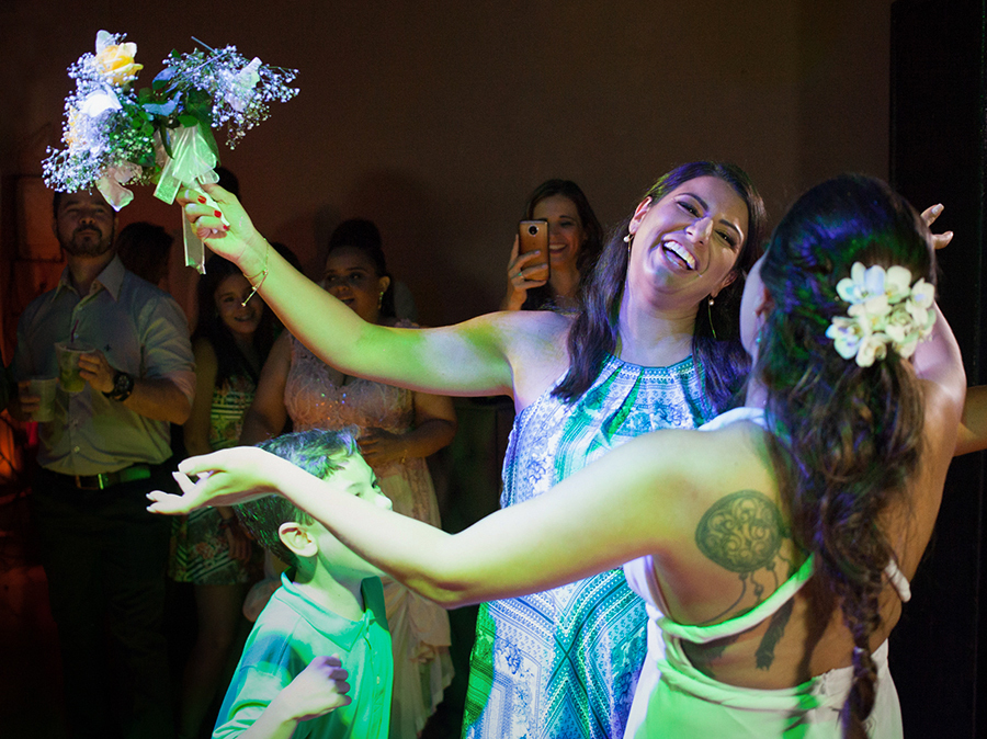 Noiva e convidada, que pegou o buquê, comemoram e se abraçam