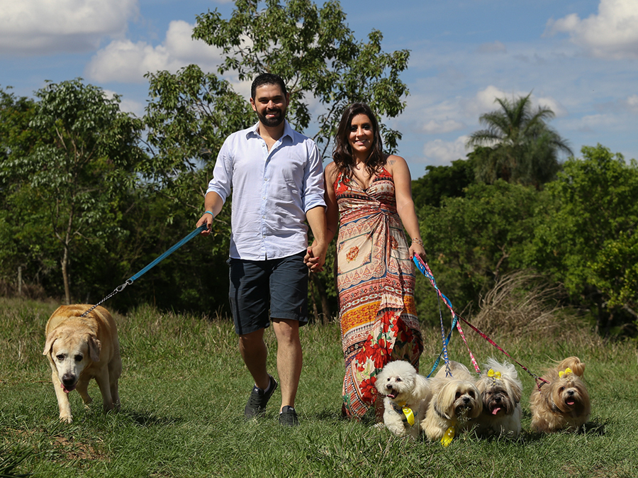 Noivos passeiam com seus cinco cachorros no campo