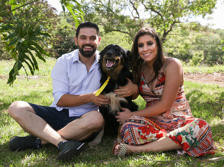 noivos posam no gramado com seu cachorro da fazenda