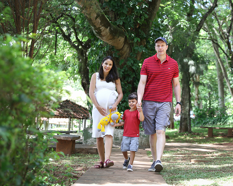 Fámilia anda de mãos dadas, por um caminho verde