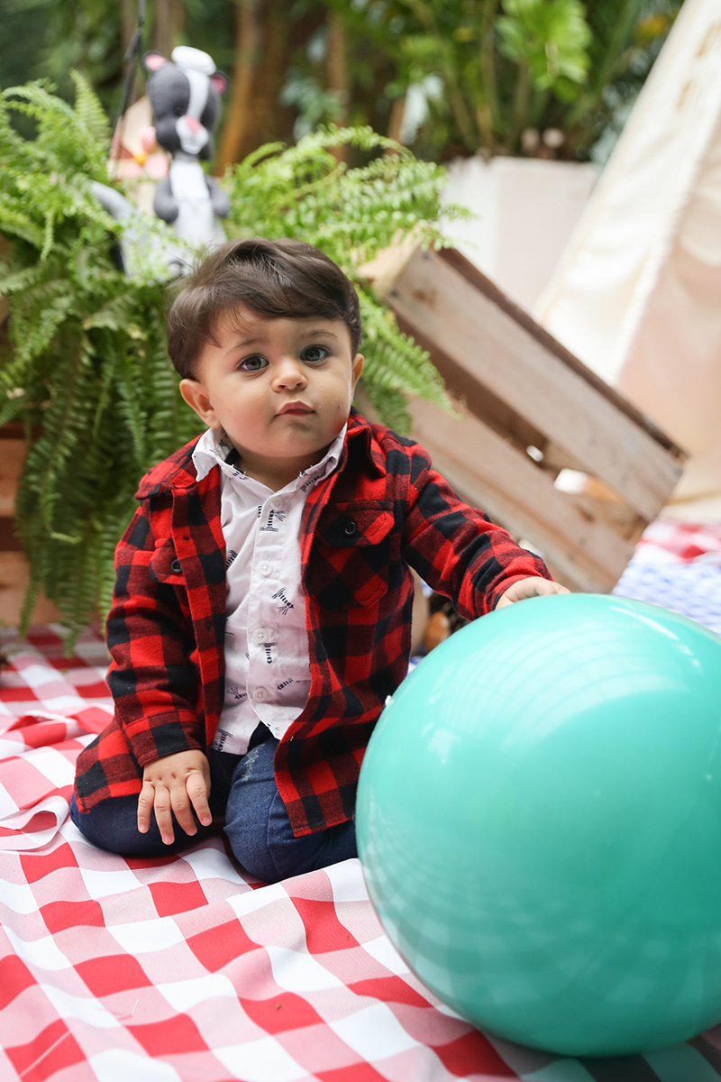 Aniversariante brinca com bola na área de picnic
