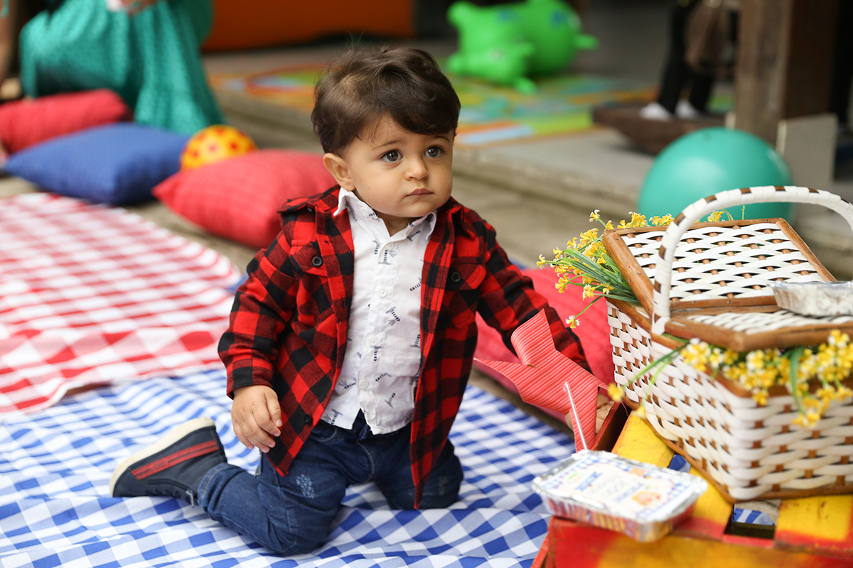 Aniversariante brinca com guloseimas da cesta de picnic