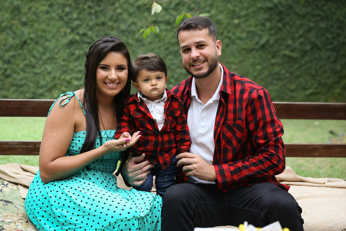 Mamãe e Papai posam com o aniversariante no banco disposto na aréa do picnic