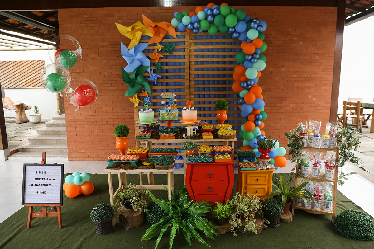 Mesa decorada no tema picnic para 1 ano do João Eduardo, nas cores verde, laranja e azul, com plantas e grama