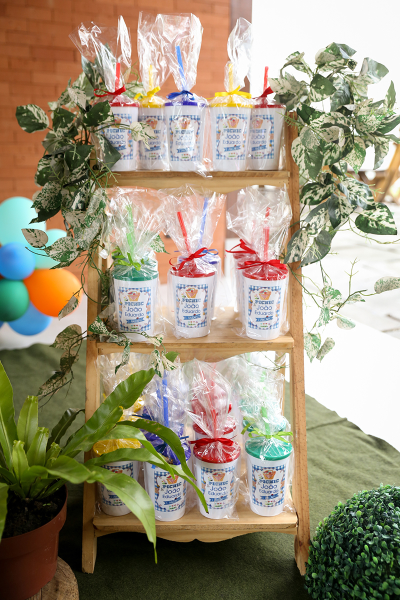 Copos de lembrancinhas dispostas na mesa de decoração