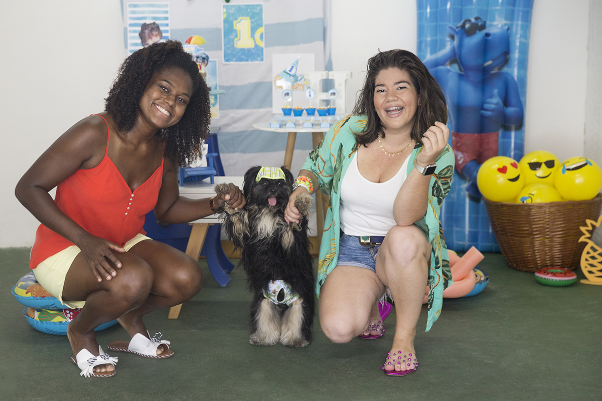 Mamães seguram Heros em frente a mesa decorada