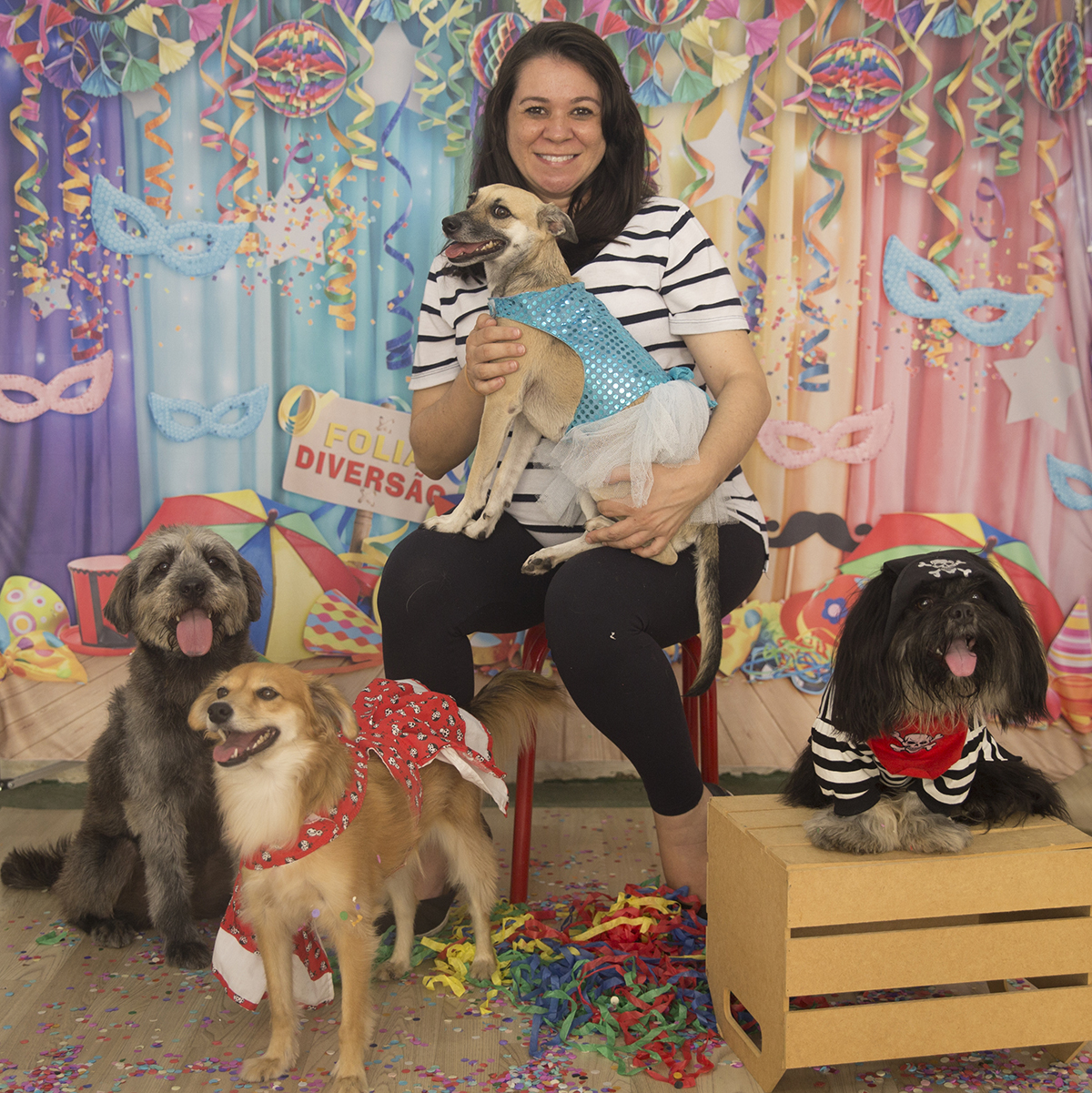 A veterinária Elli com os cães posam para as fotos no cenário de carnaval