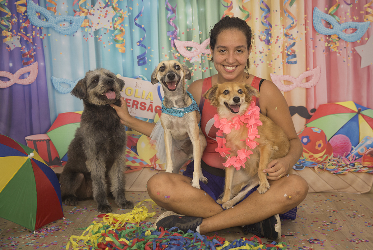 Rosane posa com as vira-latas Sol, Lua e Priscila no cenário de carnaval
