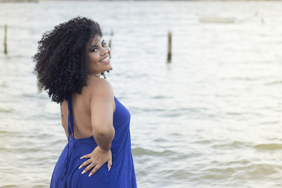 Modelo, olha sorrindo para câmera de costas