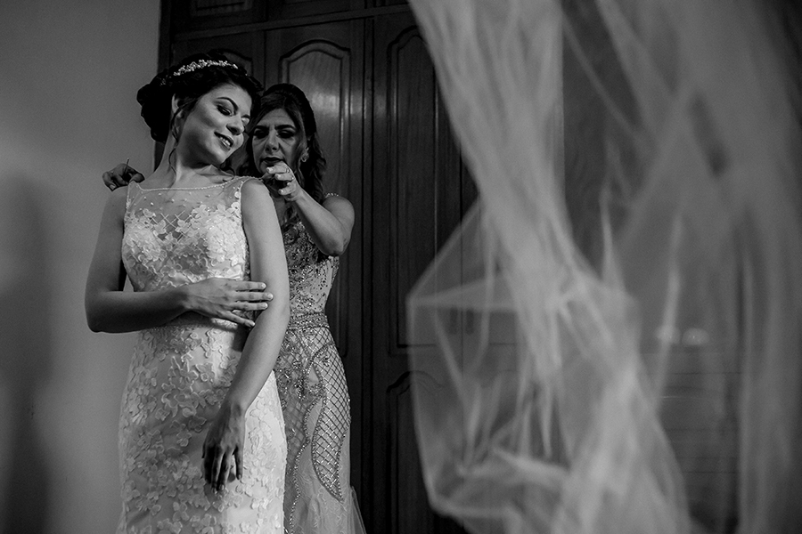 Mãe ajudando a noiva se vestir 