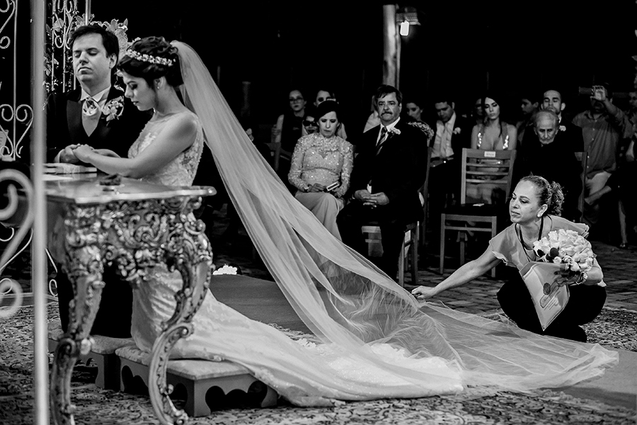 Cerimonialista arrumando o véu da noiva na hora da benção 