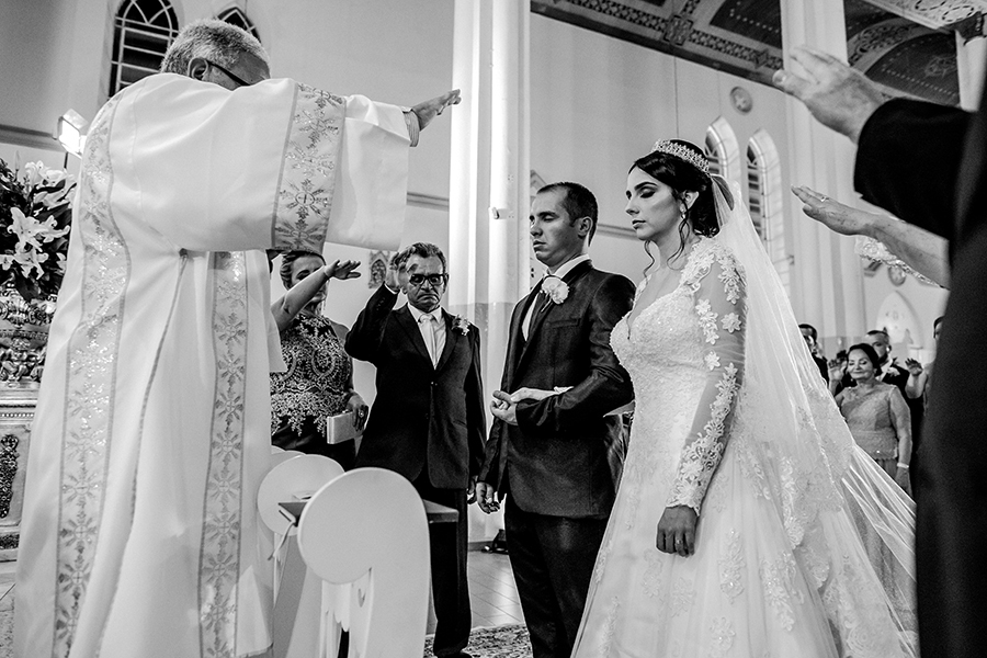 Padre e família abençoando o casal