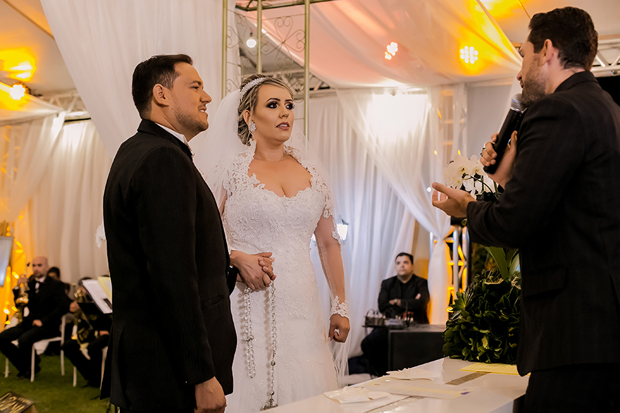 Casal no altar ouvindo atentamente o juiz 