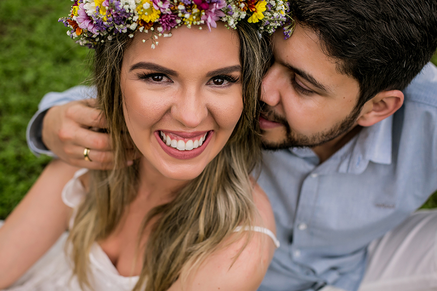 Noiva rindo com o noivo cochichando em seu ouvido