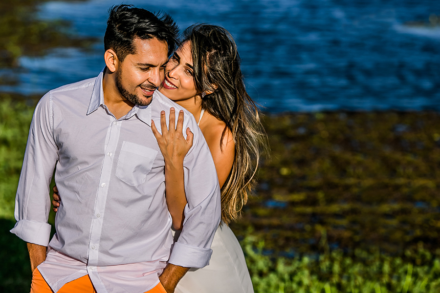 Noiva abraçando e noivo e olhando pra câmera