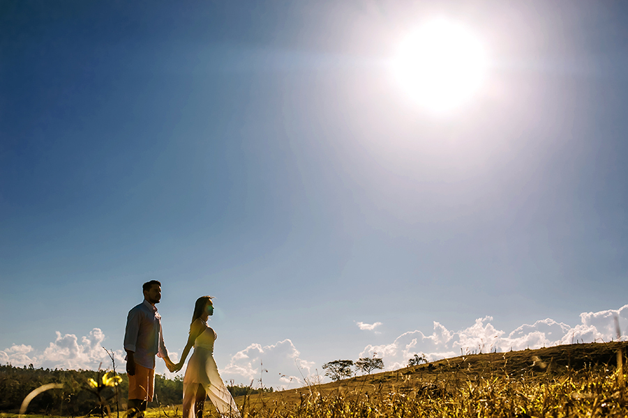 casal parado e o sol fazendo um contra luz 