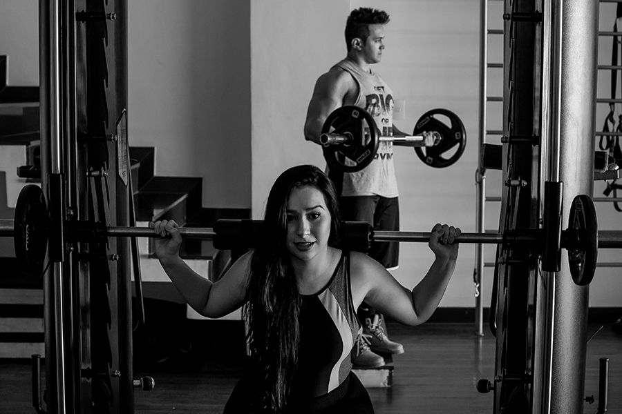 Casal pegando peso na academia 