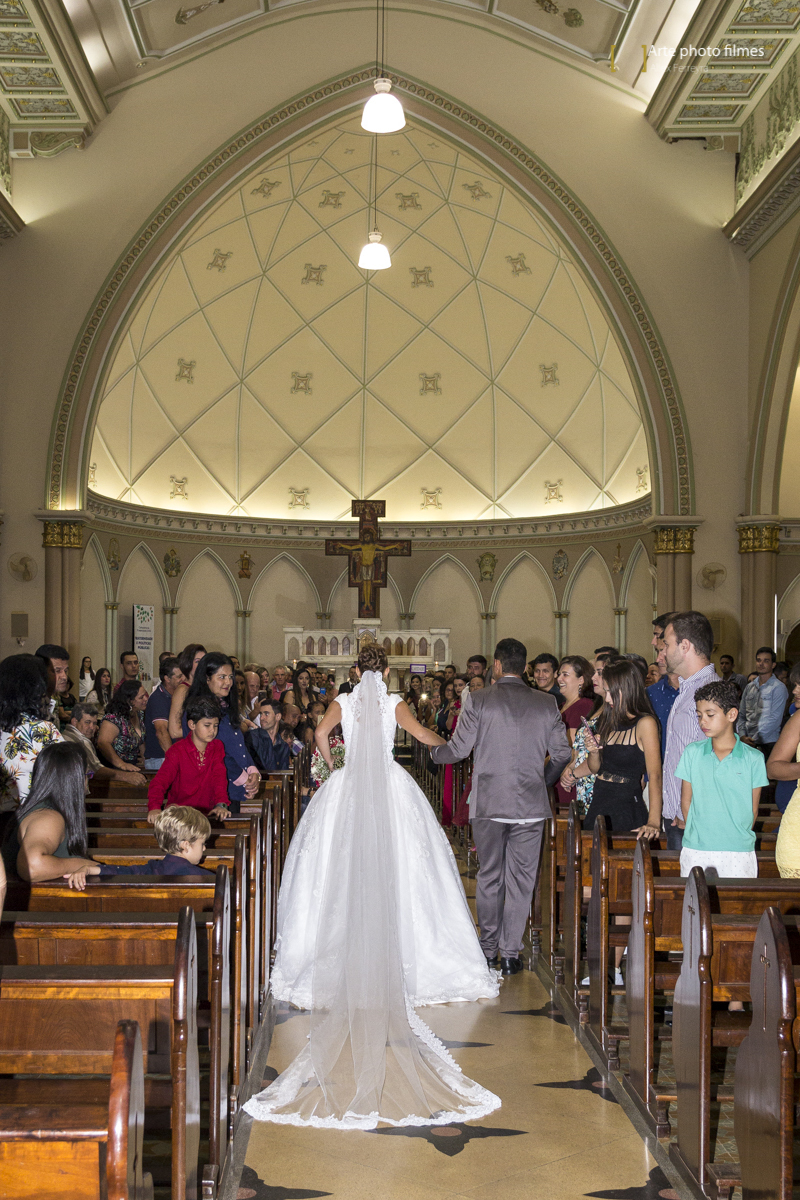 Entrada da noiva Letícia com o pai no seu casamento na Igreja Santa Terezinha em Patos de Minas-MG