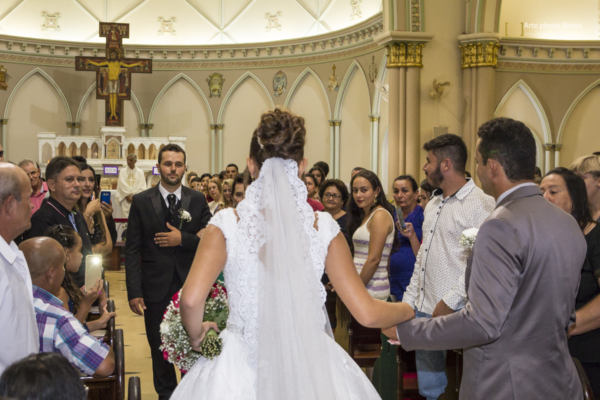 Entrada da noiva Letícia com o pai no seu casamento na Igreja Santa Terezinha em Patos de Minas-MG