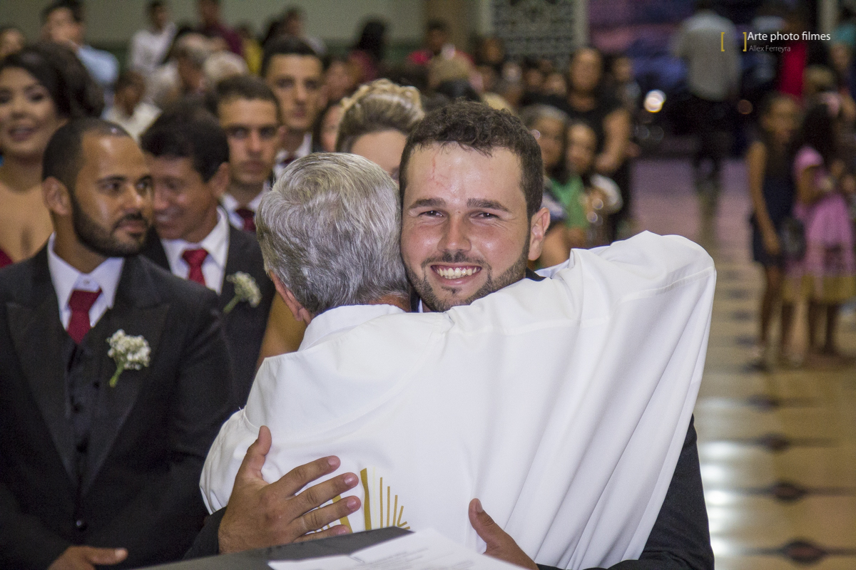 Noivo cumprimentando o padre no casamento na Igreja Santa Terezinha em Patos de Minas-