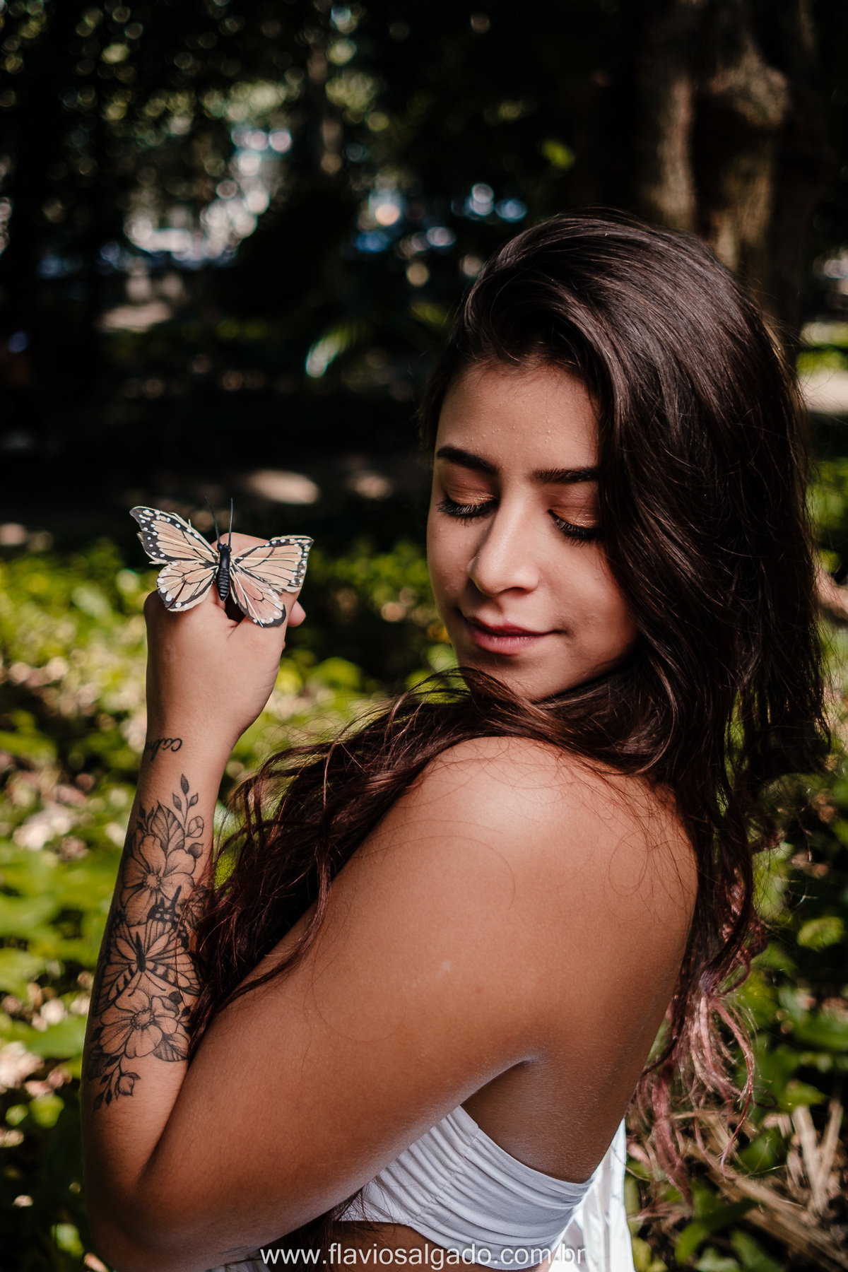 ensaio fotográfico com luz poética, com borboleta posada na mão da menina, parque laje