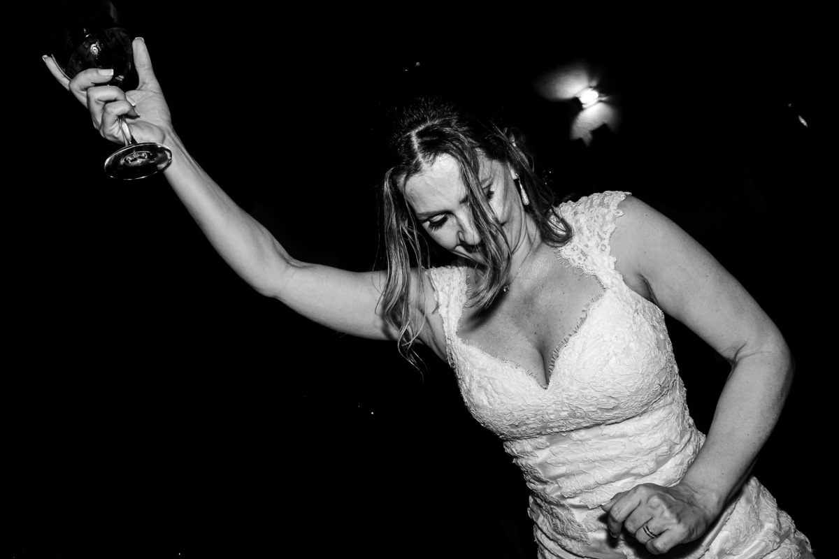 foto em preto e branco, noiva dançando animada em seu casamento