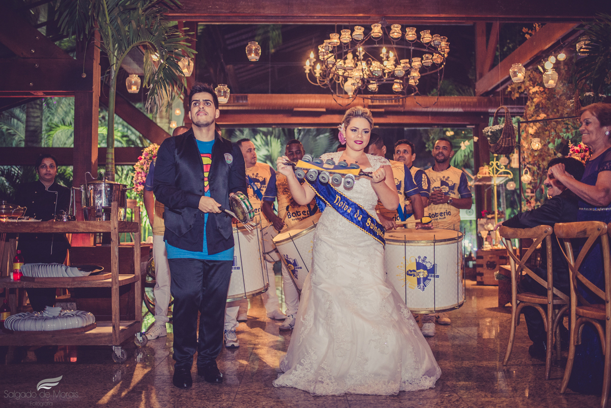 casal entrando na casa de festas com escola de samba 